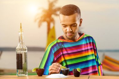 Meksikalı barmen sahilde tekila ve tuz kokteyli yapar.