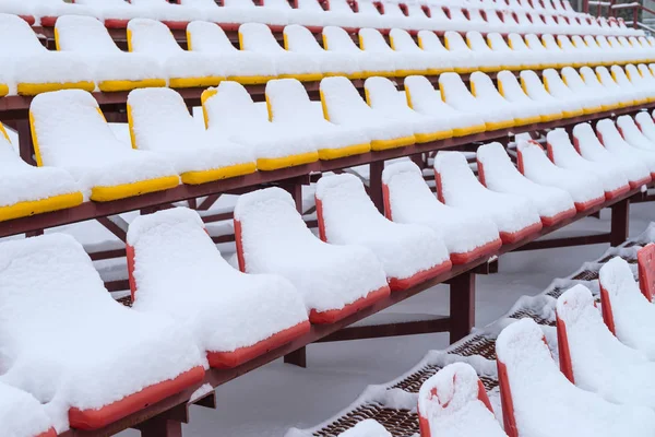 Estadio de deportes en invierno, las sillas de los fans bajo la nieve — Foto de Stock