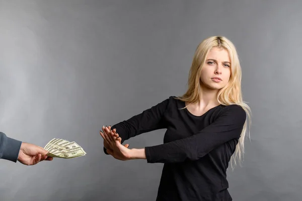 pretty blonde girl rejects money dollars banknotes woman does not take money, refusing to accept bribe money