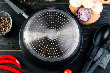 Kızartma tavası dökme demir tava ve karanlık bir tabloda, üstten görünüm yemek pişirmek için baharat boş