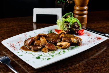 İştah açıcı mantar sos, domates ve maydanoz beyaz tabak içinde pişmiş