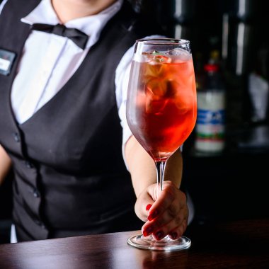 Gülümseyen ve buz küpleri ile soğuk alkollü kokteyl veren barmen