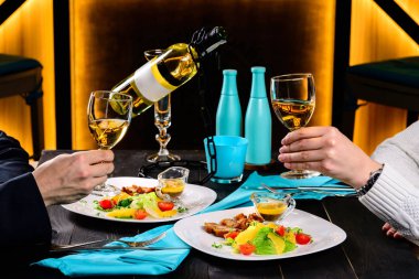 bir restoranda romantik bir akşam yemeği eller ile şarap bardakları