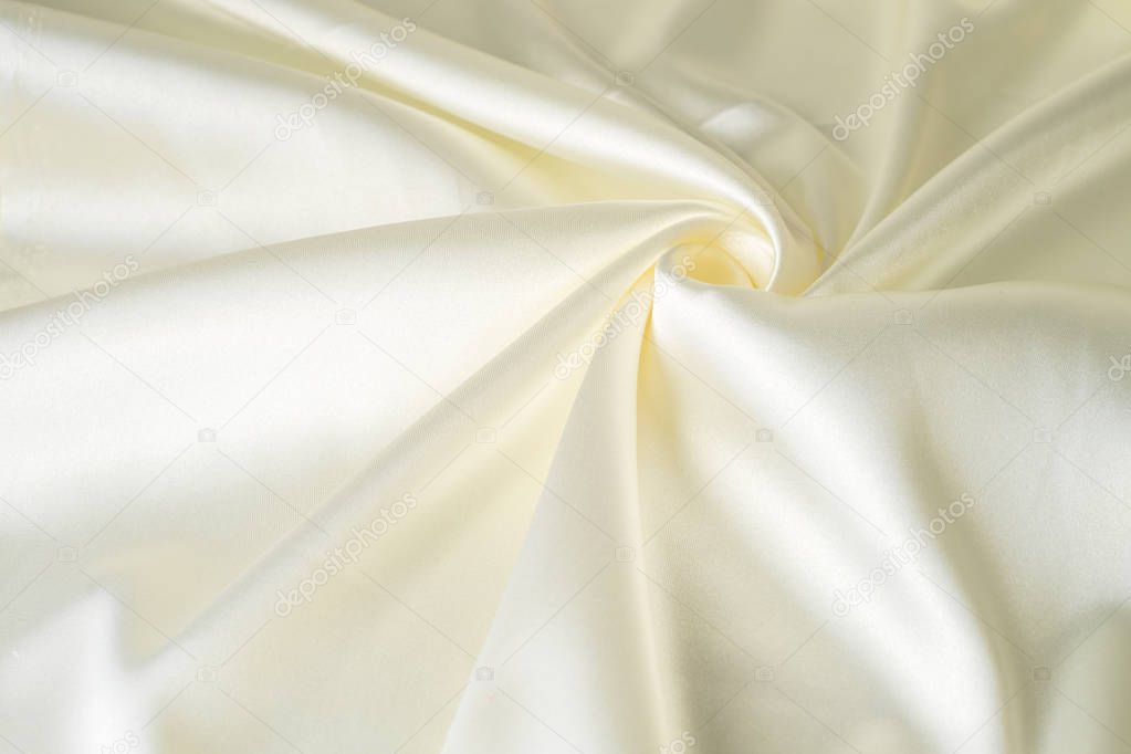 close-up of a white piece of colored satin fabric Deluxe silk cloth background with waves and drapery