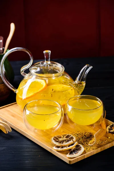 Имбирный чай с апельсином в стеклянном чайнике — стоковое фото
