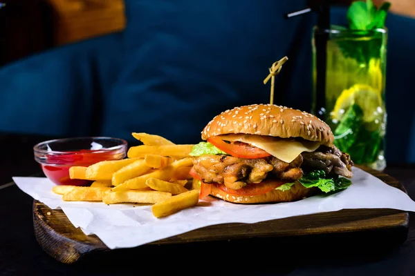 Grilované kuře a hranolky burger na černém stole v baru — Stock fotografie