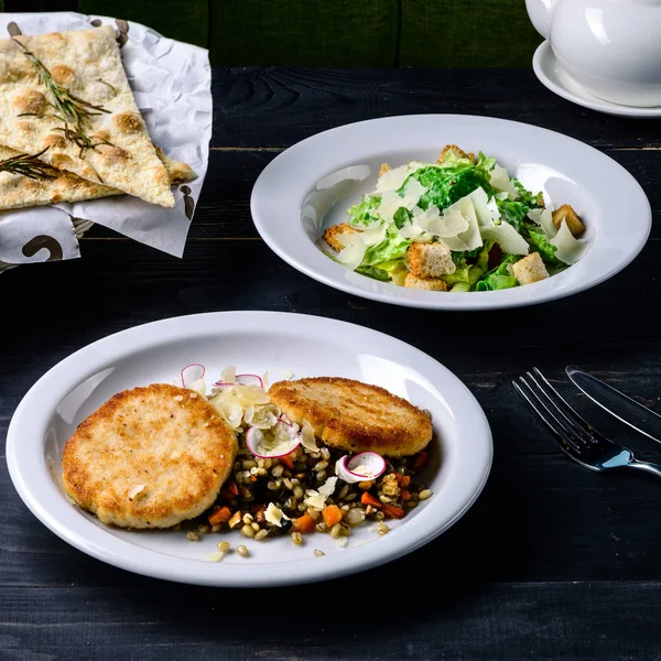 Middag duka lunch i café, kött och caesarsallad på svart bord — Stockfoto