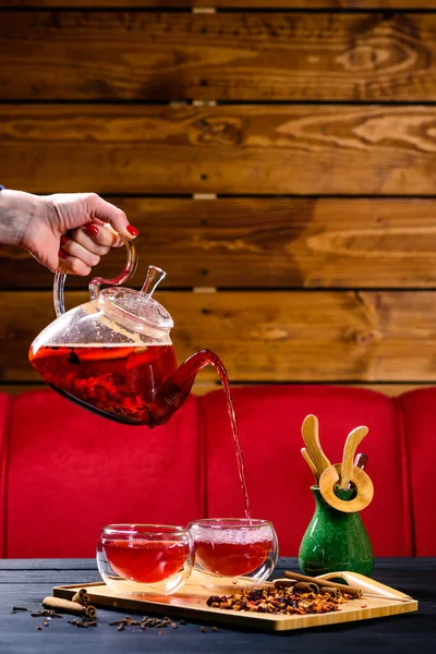 Female hand pours red tea from the teapot — Stock Photo, Image