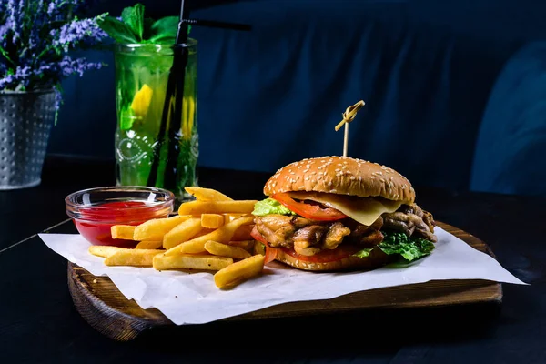Grilované kuře a hranolky burger na černém stole v baru — Stock fotografie