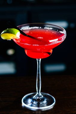 Bir gece kulübünde bar tezgahında limonlu Cosmopolitan kokteyli.