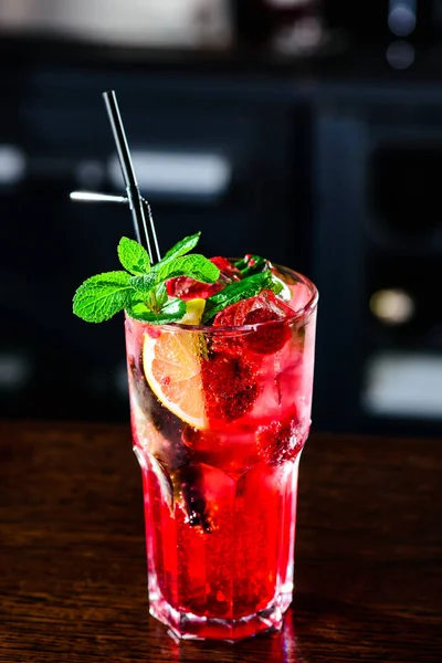 Limonada Mojito rosa frambuesa con lima y menta fresca en vaso en el mostrador de un bar en un club nocturno. Cóctel refrescante de verano . —  Fotos de Stock