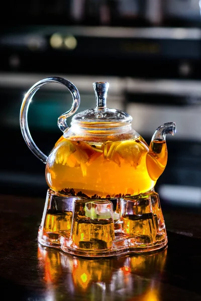 Glas tekanna med frukt varmt te i ett café med apelsin — Stockfoto