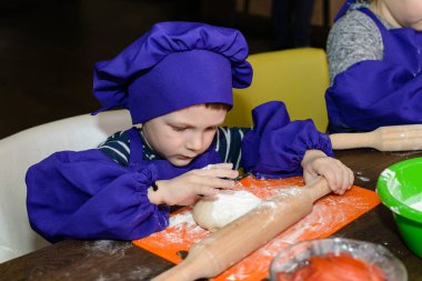 şirin ufaklikla chef şapka ayakta masada ekmek hamur yoğurma