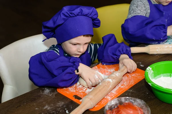 Niño con sombrero de chef preparando la masa de pizza — Foto de Stock