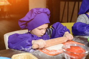 Çocuklar pizza yapar. İtalyan pizzası pişiren çocuklar için master class. Küçük çocuklar pizza pişirmeyi öğrenirler. Ev yapımı pizza hazırlayan çocuklar