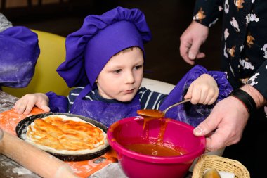 Çocuklar pizza yapar. İtalyan pizzası pişiren çocuklar için master class. Küçük çocuklar pizza pişirmeyi öğrenirler. Ev yapımı pizza hazırlayan çocuklar