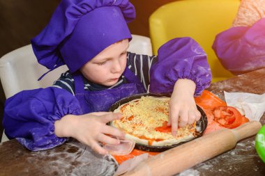 Çocuklar pizza yapar. İtalyan pizzası pişiren çocuklar için master class. Küçük çocuklar pizza pişirmeyi öğrenirler. Ev yapımı pizza hazırlayan çocuklar
