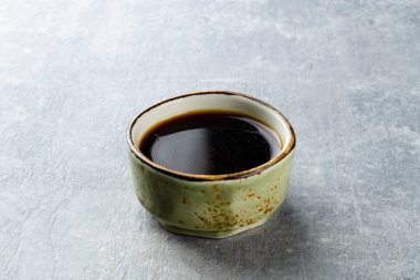 gri taş arka plan üzerinde bir tabakta soya sosu