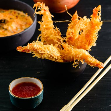 Batter içinde kaplan karidesleri. Siyah arka planda baharatlı sos ile Ebi tempura