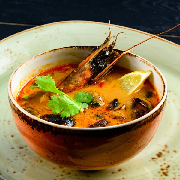Karanlık masada balık, karides ve istiridye ile sıcak deniz ürünleri çorbası — Stok fotoğraf