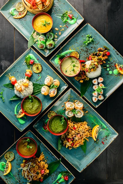 asian cuisine, lunch on a tray top view on a black table food background