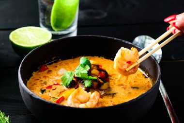 Siyah ahşap arka planda baharatlı deniz ürünleri noodle.