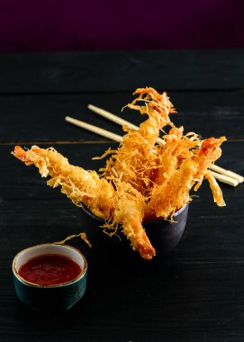 Batter içinde kaplan karidesleri. Siyah arka planda baharatlı sos ile Ebi tempura