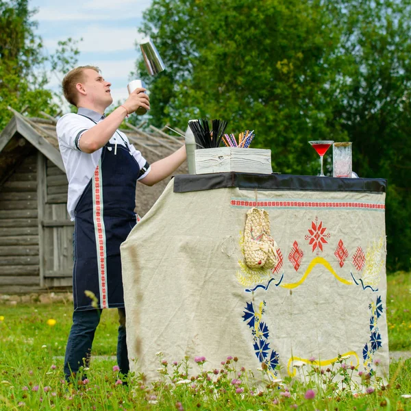 Catering-Bar-Service, Barkeeper-Show. schöner Barkeeper, der Cocktails in der Nähe der Theke zubereitet, im Freien — Stockfoto