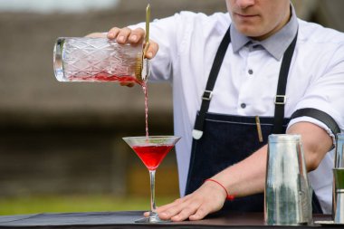 catering bar hizmeti. Kalkışta barmen işi. Yakışıklı barmen açık havada kokteyl hazırlanıyor