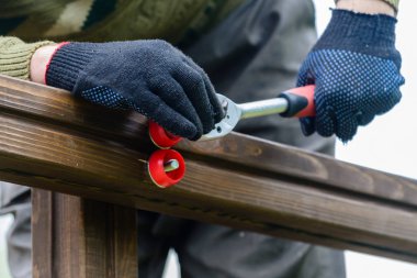 adamın eli cıvata ve somun sıkılaştırır. Yapı ve onarım konsepti, ahşap cıvata ve hex somun.