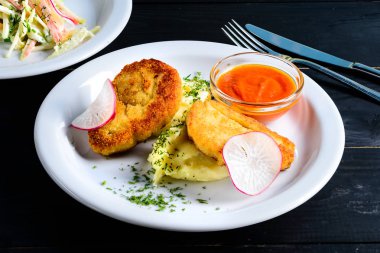 Kavrulmuş tavuk göğsü rulo masada beyaz tabak patates püresi ile tavuk ve domuz eti ile doldurulmuş