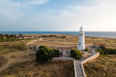 Issız sahil ve günbatımı, Paphos Kıbrıs beyaz bir deniz feneri havadan görünümü