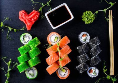 Set siyah taş masanın üzerine rulo suşi ve suşi.