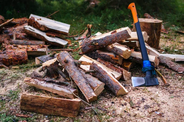 Legna da ardere tritata e un'ascia incastrata in un tronco d'albero. ascia legna da ardere — Foto Stock