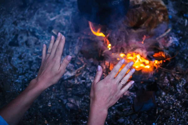 Frauenhände wärmen sich am Feuer — Stockfoto
