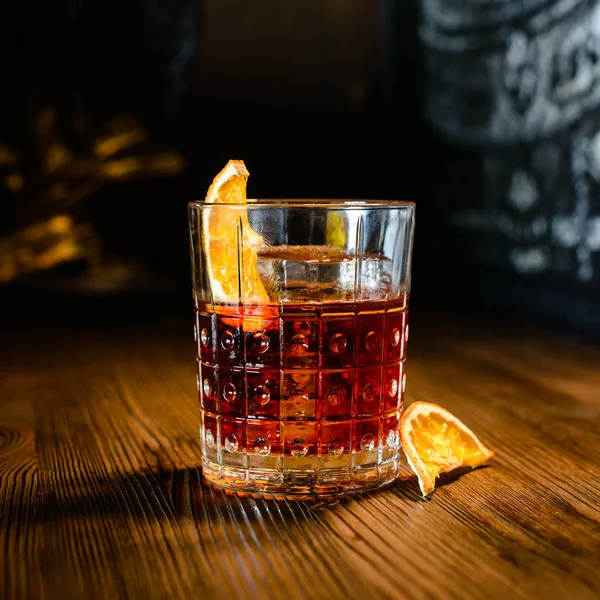 Eski bir tahta üzerinde Negroni kokteyli. Cin, Campari Martini Rosso ve portakallı.