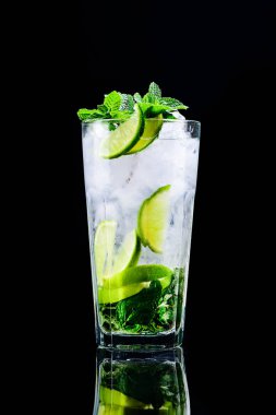 Koyu arkaplanda yansıması olan klasik mojito kokteyli.