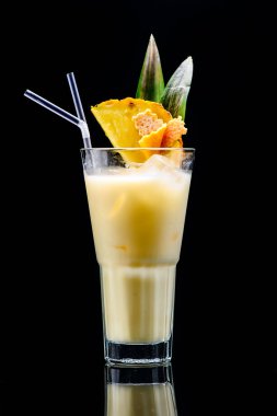 Koyu arkaplanda yansıması olan klasik pina colada kokteyli.