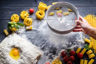 Noel kurabiyeleri için yumurta, tereyağı ve sütle hamur pişiren kadın fırıncı.