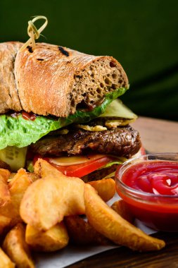 Barbeküde pişmiş taze burger. Amerikan bbq yemeği. Biftek etli ve sebzeli büyük hamburger. Sokak yemeği, fast food. Büyük hamburgerci çavdar ekmeği.