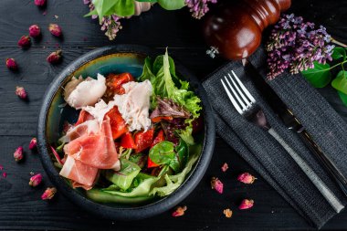 Taze salata parmesanlı, jambonlu, roka ve parmesanlı taze salata. Siyah arkaplan, üst görünüm.