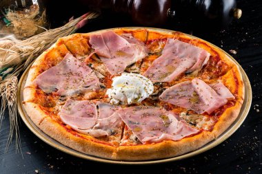 Jambonlu İtalyan pizzası, haşlanmış yumurta, jambonlu Capricciosa pizzası, siyah arka planda jambon.
