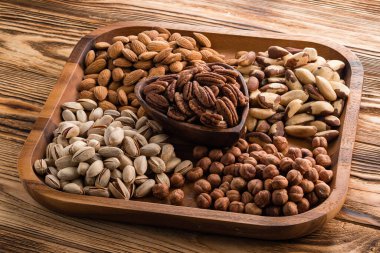 Fındık çeşitleri: ceviz, fındık, kaju, ahşap arka planda yer fıstığı.