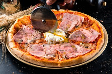 Jambonlu İtalyan pizzası, haşlanmış yumurta, jambonlu Capricciosa pizzası, siyah arka planda jambon.