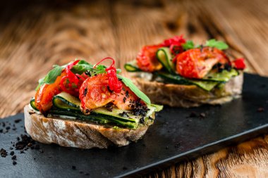 Lezzetli domatesli bruschetta. Kolay aşçı, besleyici atıştırmalık. Güzel dekore edilmiş yemek ziyafeti menüsü. Açık büfe için atıştırmalık ve aperatif. Domates ve salatalıklı bruschetta.