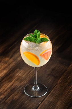 Portakal dilimleri ve nane şekeri ile süslenmiş beyaz şarap kadehi. Klasik beyaz şarap sangria.