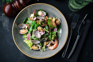 Midye ve karidesli deniz ürünleri salatasının en üst görüntüsü bir restoranda gurme mutfağı sunuyor. Restoran masasında servis edilen salata kasesi. Manzaralı yemek. Boşluğu kopyala