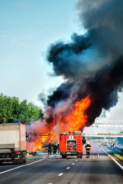 Kaza ve yangın dikey olarak yolda, yolda siyah dumanla yanan bir kamyon.