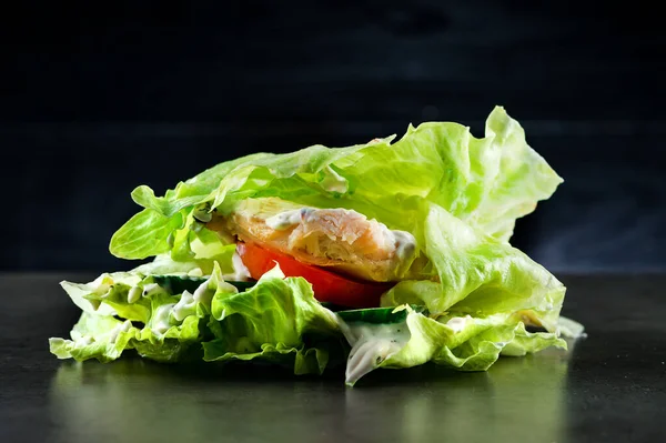 Keto burger, lettuce wrapped burger, low-carb with chicken breast, closeup of juicy grilled chicken fillet