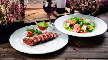 Biftek, sebze salatası, ahşap masa, öğle yemeği, biftek ve sebze salatası.